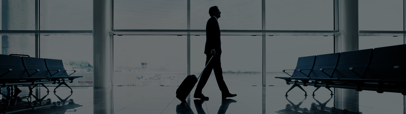 Un homme qui marche dans un aéroport avec sa valise