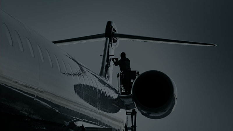 MHIRJ engineer doing maintenance under a plane